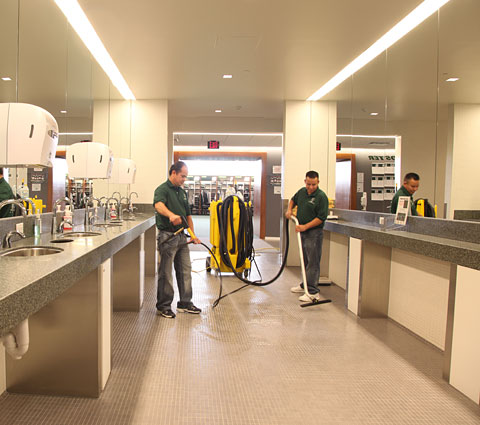 A group of men cleaning the floor in a room.